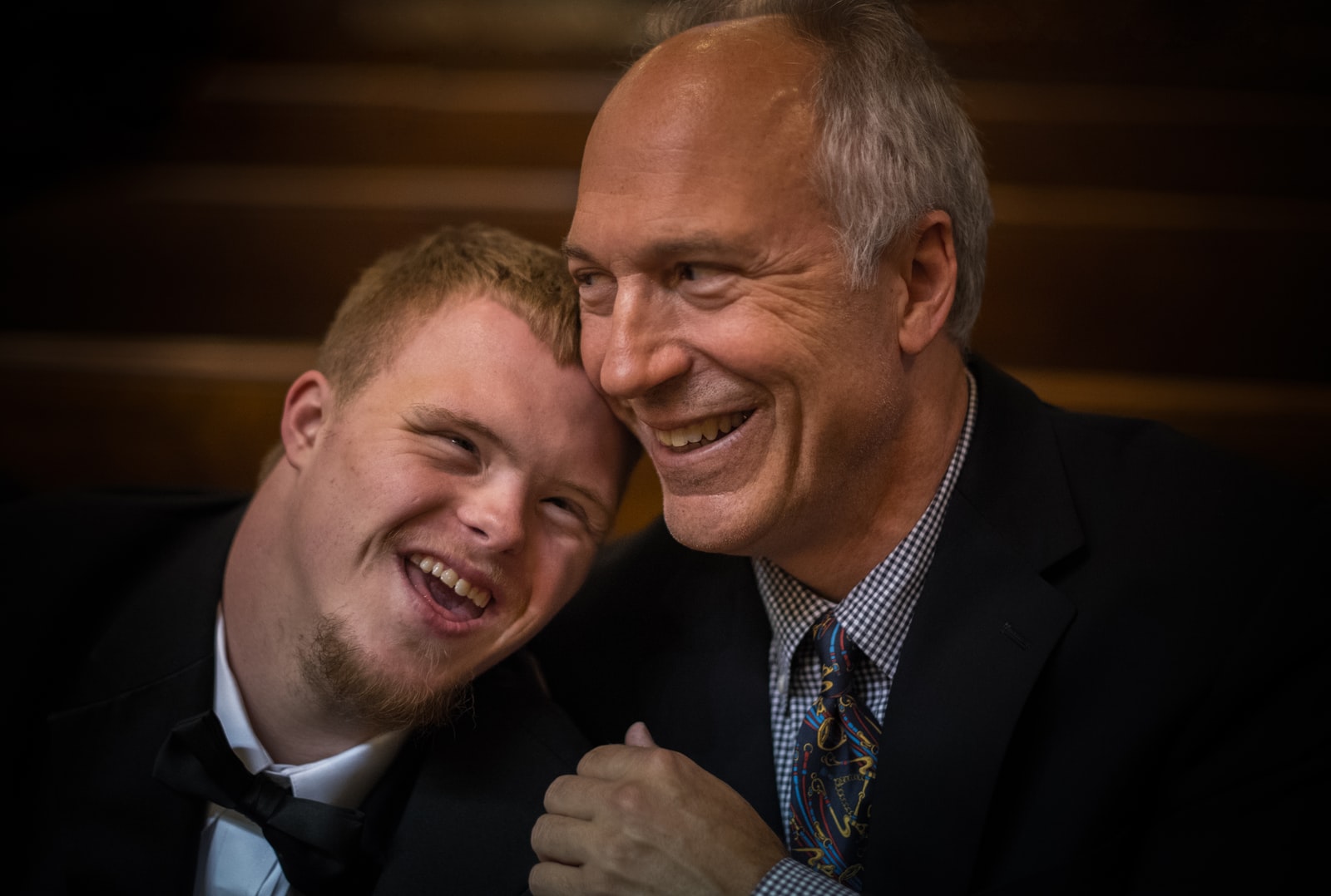 Older man smiling at younger man with down syndrome